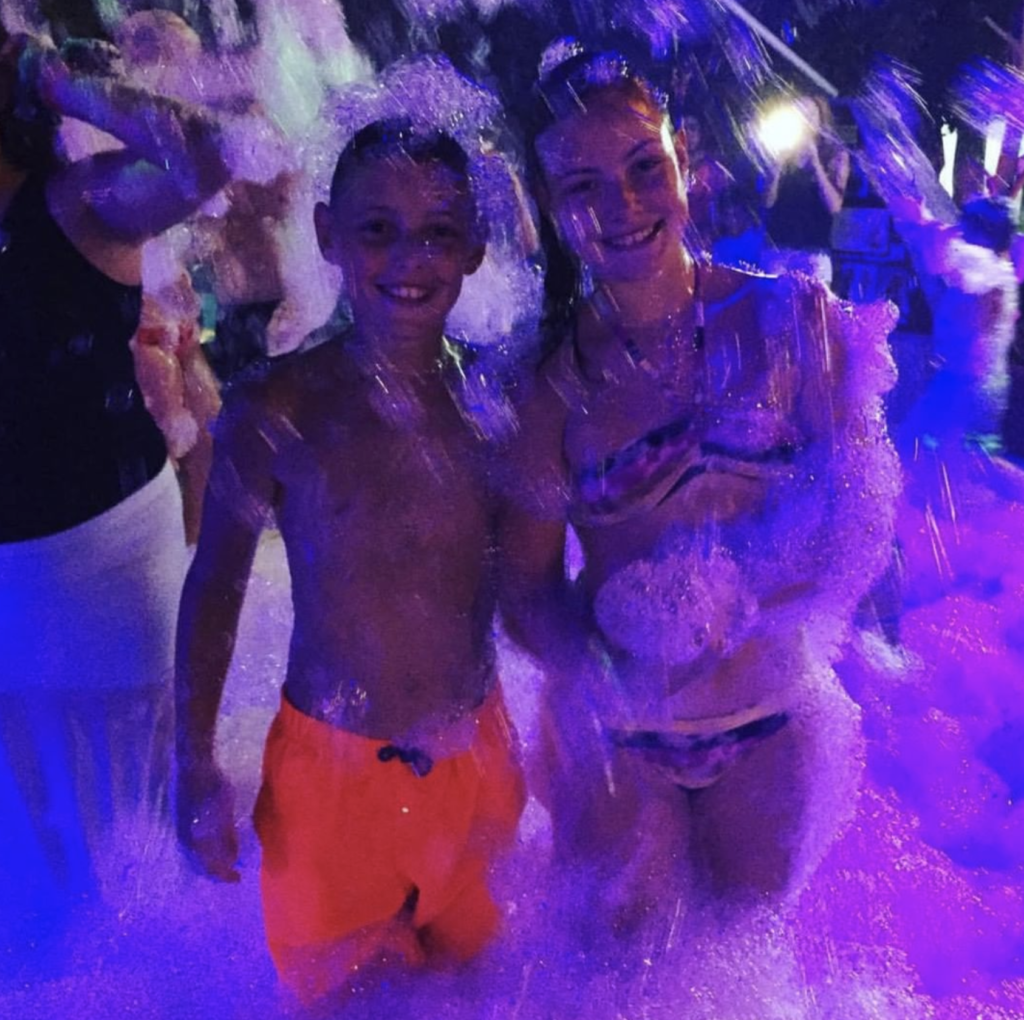 Teens smiling at the camera at a foam dance event